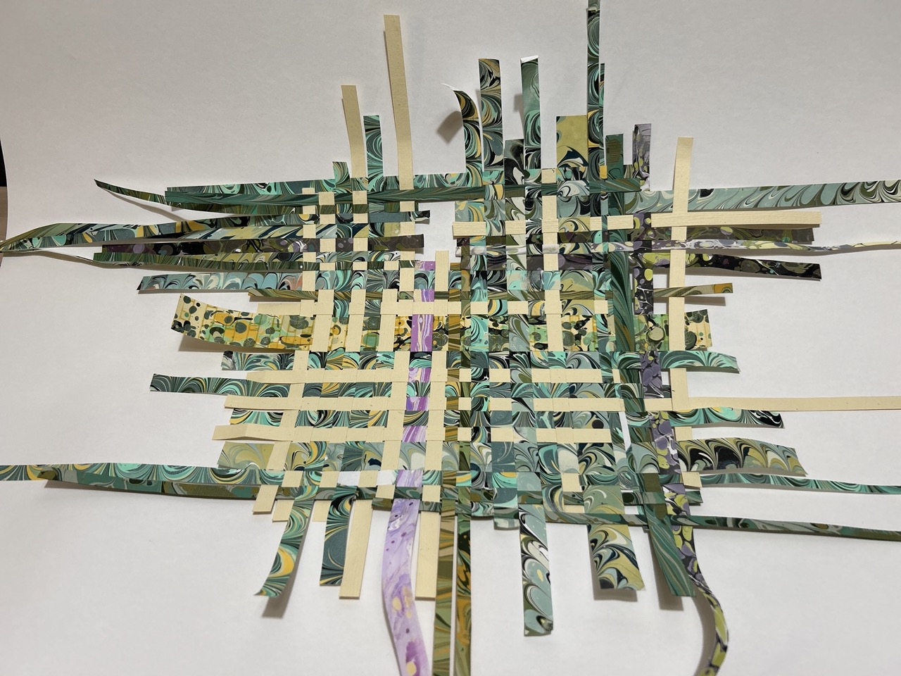 paper weaving with strips of cream and green marbled paper.